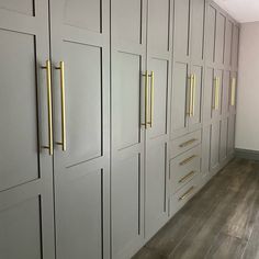 an empty room with white cabinets and gold handles on the doors is seen in this image