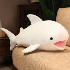 a white stuffed dolphin sitting on top of a chair