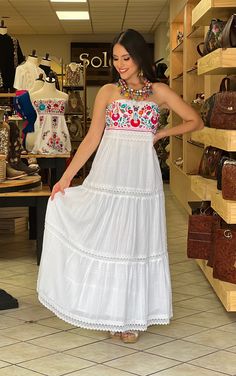 This Beautiful Strapless Dress boasts a Traditional Mexican floral design combined with a modern style dress. The corrugated skirt combined with the strapless embroidered top makes it fun and flirty. It's made out of fine Mexican corrugated cotton and has elastic on the back for a tighter fit. It has lace details throughout. This dress is handmade and completely hand embroidered by Mexican Artisans in Puebla, Mexico. More available dresses here: https://www.etsy.com/es/shop/SoleiEthnic?ref=selle Mexican Wedding Dress Guest, Mexican Fiesta Dresses For Women, Bohemian Embroidered Sleeveless Maxi Dress, Summer Fiesta Maxi Dress, Bohemian Sleeveless Embroidered Maxi Dress, Bohemian Strapless Spring Dresses, Bohemian Sleeveless Embroidered Beach Dress, Traditional Sleeveless Summer Maxi Dress, Bohemian Sleeveless Dress With Embroidered Hem