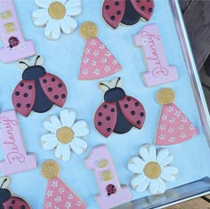 ladybugs and daisies decorated cookies on a tray