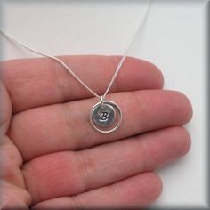 "A lovely sterling frame encircles a small initial charm. Personalized and simple - the perfect neckace to stand alone or layer, as you wish. Each initial is handstamped and then slightly darkened to stand out on the sterling disc. The pendant measures slightly larger than 1/4\" round (9 mm). Sterling silver curb chain. All other components are sterling silver. Jewelry is packaged in a cotton lined box for gift-giving. See more Bonny Jewelry at http://bonnyjewelry.etsy.com If this is a gift and Sterling Silver Charm Necklace Gift, Sterling Silver Circle Charm Necklace For Gift, Silver Circle Sterling Silver Charm Necklace, Silver Circle Charm Necklace In Sterling Silver, Silver Sterling Silver Circle Charm Necklace, Adjustable Sterling Silver Round Charm Necklace, Adjustable Round Sterling Silver Charm Necklaces, Sterling Silver Charm Necklaces, Simple Bridesmaid Gift