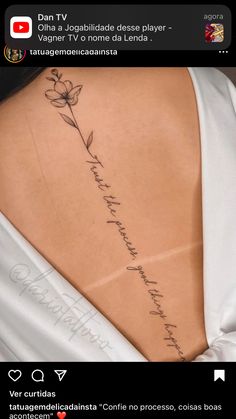 the back of a woman's neck with a flower tattoo on her left side