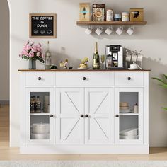 a white buffet table with open doors and shelves on the wall, next to a potted plant