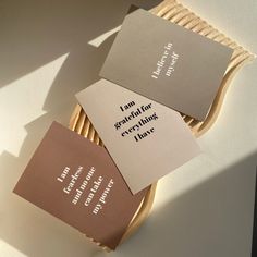 three business cards sitting on top of a wooden basket next to a white and brown wall