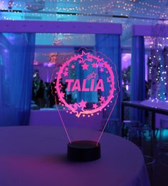 a table with a light up sign on it that says talia in the center