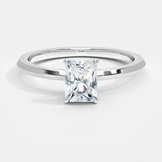 a princess cut diamond engagement ring on a white background with the center stone in the middle