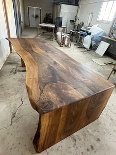 a large wooden table sitting inside of a room next to other tables and chairs on the floor