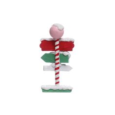 a red and green street sign sitting on top of snow covered ground next to a candy cane