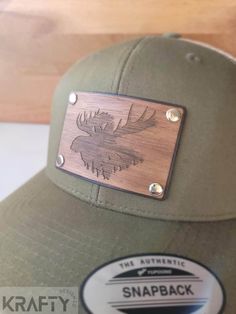 If you've been looking for that patch hat thats unlike all the rest, look no further. These patches are made up of hand dyed genuine leather with a laser engraved walnut overlay, all bonded and riveted to the hat producing a look that will be scoring compliments everywhere you go.  it should go without question that a special patch like this made from wood should be hand cleaned only. The wood has been treated with beeswax and mineral oil to give it a beautiful sheen and also help repel moisture Custom Brown Snapback Baseball Cap, Custom Trucker Hat With Leather Patch Snapback, Custom Snapback Trucker Hat With Leather Patch, Custom Outdoor Trucker Hat With Leather Patch, Custom Trucker Hat With Leather Patch For Outdoor, Brown 5-panel Snapback Hat With Leather Patch, Leather Patch Hat Ideas, Hat Patch Ideas, Personalized Hats