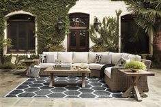 an outdoor living room with wicker furniture