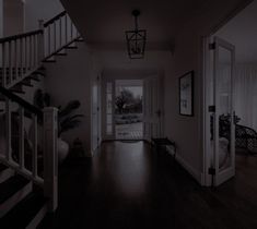 an empty hallway with stairs leading to the front door