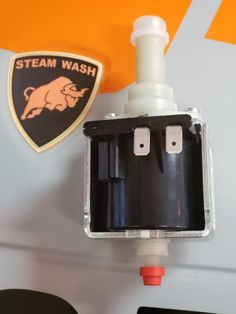 an image of a steam wash machine attached to the side of a wall with a badge on it