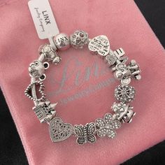 Linx Snake Chain Style Charm Bracelet In 925 Sterling Silver, With A Ball Clasp. The Bracelet Is 3mm In Width And Available In Multiple Lengths. This Bracelet Comes With 13 Unbranded Charms In Sterling Silver With Other Alloy Metals. Additional Charms Can Be Added Also. All Items Are New And Come In A Luxury Velvet Jewelry Pouch. Charms Are Not Linx Brand, They Are A More Affordable Alternative. Silver Charms Chain Bracelet For Everyday, Elegant Silver Charms For Everyday, Everyday Silver Charm Bracelet With Lobster Clasp, Silver Charms Jewelry For Everyday, Elegant Silver Bracelets With Charms, Elegant Silver Charms, Metal Charm Bracelet With Sterling Silver Clasp As Gift, Silver Charms For Everyday, Gift Metal Chain Bracelet With Silver Beads