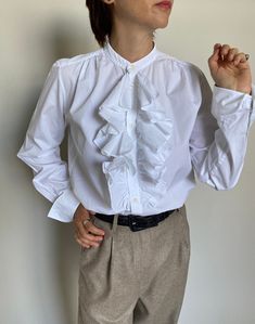 "White Cotton Blouse for Women Size 10 | Ralph Laurent White Blouse with Ruffled Front and French cuffs. Composition: 100% cotton. Size on tag: 10 Measurements of the vintage white blouse lying flat: chest: 51 cm | 20.1\" length: 65 cm | 25.6\" sleeves: 60 cm | 23.6\" shoulder to shoulder: 38 cm | 15\" In excellent vintage condition.  The model wearing this classic white blouse is 1,68 m | 5.5 foot tall; Chest: 88 cm | 35\", waist: 68 cm | 26\", hips: 88 cm | 35\".  The beige herringbone pants i Classic Cotton Top With Ruffled Collar, Classic Formal Shirt With Ruffles, Classic Office Shirt With Ruffled Collar, Classic Cotton Shirt With Ruffles, Classic Shirt With Ruffled Collar For Office, Classic Ruffled Shirt For Office, Cotton Blouse With Ruffled Collar, Cotton Blouse With Ruffled Collar And Details, Cotton Ruffle Blouse For Daywear