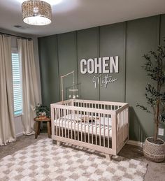 a baby's room with a crib in the corner and a sign on the wall