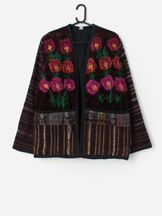 Vintage handmade embroidered floral jacket in brown. This gorgeous mixed brown jacket features beautiful embroidered flowers in red, purple and pink on the front and purple, orange and grey stripes throughout. This jacket also features two large open pockets above the hem and has edge to edge no fastening.  Handmade from a soft, heavyweight cotton.  Our recommended size: Medium to large Label says: No size label Condition: Very good  Material: 100% cotton Measurements in inches: Pit to pit: 22 Shoulders: 18 Front length: 29 Back length: 29 Sleeve length: 25 Hem: 22 We recommend that you compare our measurements to a similar item of your own to ensure good fit. Measurements are taken flat and doubled for waist and hip. Our items are vintage and may show signs of previous wear, etc. Any sign Brown Floral Embroidery Outerwear For Fall, Brown Floral Embroidered Fall Outerwear, Brown Floral Embroidered Outerwear For Fall, Brown Floral Embroidered Winter Outerwear, Brown Floral Embroidered Outerwear For Winter, Winter Brown Outerwear With Floral Embroidery, Brown Embroidered Long Sleeve Outerwear, Fall Floral Print Multicolor Embroidered Outerwear, Fall Floral Print Outerwear With Multicolor Embroidery