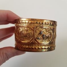 "Unique brass/ brass colored vintage bangle bracelet featuring an array of semi abstract animals.  It is aged and worn, adds to the charm! It is also a little bent. It is not marked so I am not sure the metal, possibly copper or brass Measures approx. 3\" diameter. 1 1/2 inches wide" Antique Gold Cuff Bracelet Collectible, Engraved Bronze Brass Bangle, Antique Engraved Bronze Cuff Bracelet, Vintage Brass Bangle For Gift, Vintage Brass Bangle Bracelets, Vintage Brass Bangle Bracelet, Vintage Brass Bracelets With Etched Details, Bronze Metal Bracelet With Patina, Antique Brass Cuff Bracelet Collectible