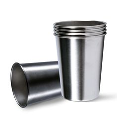 a set of four stainless steel cups sitting next to each other