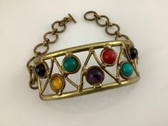 Mid century bracelet. Rounded soldered focus, with inset multicolored stones. Multi-stone Metal Bracelet, Vintage Multicolor Stone Bracelets, Multicolor Metal Bracelets With Stones, Metal Bracelets With Multicolor Jeweled Details, Vintage Multicolor Cabochon Bracelets, Donut Shoes, Rad Clothes, Victorian Boots, Blue Sandals