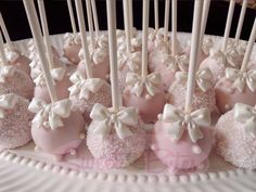 there are many pink and white cake pops on the plate