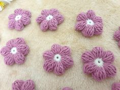 several crocheted flowers sitting on top of a white rug