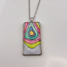 The lines in these paintings remind me of a topographical map. I imagine each of these pendants as a representation of a unique island that would be perfect for escaping the daily stressors of life. Six unique pendants were painted with these colors, and each is truly one of a kind! This pendant measures 1" wide by 2" tall (25mm x 50mm) and comes on an 22" chain. Jewelry comes on a presentation card in a white organza bag, ready to be gifted. Artistic Multicolor Abstract Jewelry, Artistic Multicolor Jewelry With Abstract Design, Artistic Multicolor Abstract Design Jewelry, Artsy Multicolor Round Pendant Necklace, Artistic Pendant Necklace With Artistic Design, Wearable Art Necklace With Large Pendant, Artsy Green Pendant Necklace, Unique Multicolor Necklace, Unique Multicolor Rectangular Necklace