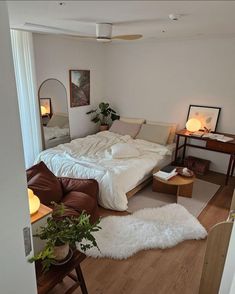 a bed sitting in the middle of a living room next to a table and chair