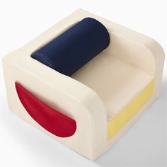 a white couch with a red, yellow and blue pillow on it's back