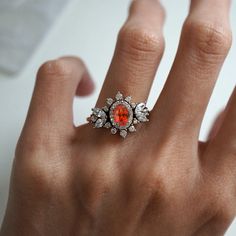 Immerse yourself in a world of timeless beauty with our Coco Fanta Orange Spessartite Garnet Coco Diamond Ring, a true testament to class and elegance. This ring seamlessly combines the grace of marquise and round diamonds, elevating the sense of style on the wearer. A proportionately beautiful design with a touch of vintage charm, it features a natural vivid Orange Spessartite adorned with the brilliance of natural white diamonds. Handcrafted with precision, this ring is available in 14K and 18K yellow gold, rose gold, and white gold. Only one available. Spessartite/Spessartine is known for its fiery red-orange color, hence why it's called the "Garnet of the sun". Spessartine garnet is a stone known for positive emotions and creativity. It encourages a rational state of mind, emotional st Orange Multi-stone Wedding Jewelry, Orange 14k Gold Wedding Ring, Orange Oval Jewelry For Wedding, Heirloom Orange Jewelry For Anniversary, Heirloom Orange Ring As Gift, Heirloom Style Orange Ring For Gift, Heirloom Orange Ring For Gift, Heirloom Orange Gemstone Ring, Fanta Orange