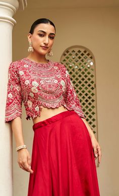 Carmine red top with all over floral embroidery using zardozi, aari work, french knots, and dori work, the style of the top amps up with an asymmetrical skirt.