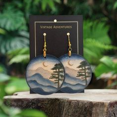 Mountain landscapes are some of the most breathtaking sights that nature has to offer. They inspire awe and wonder in anyone who takes the time to appreciate them. That's why these Mountain Landscape Dangle wood earrings are such a special and unique piece of jewelry. Handcrafted from lightweight materials, these hand-painted wooden earrings feature one-of-a-kind designs that capture the beauty and majesty of the mountains. Whether you're an avid hiker or simply appreciate the natural beauty of the world, these earrings are a must-have addition to your collection. The intricate detailing of the painted designs is truly impressive, and the lightweight construction makes them comfortable to wear all day long. Plus, the one-of-a-kind designs mean that you'll never see another pair of earrings Handmade Natural Nature-inspired Earrings, Natural Wood Drop Earrings, Handmade Natural Color Nature-inspired Earrings, Handmade Natural Earrings With Nature-inspired Style, Handmade Natural Wood Earrings As Gift, Handmade Natural Wood Earrings For Gift, Nature-inspired Natural Wood Earrings As Gift, Nature-inspired Natural Wood Earrings For Gift, Natural Wood Nature-inspired Jewelry