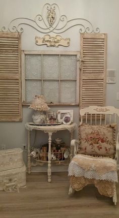 an old fashioned chair and table in a room with shuttered window panes on the wall