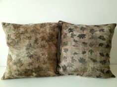 two pillows sitting on top of each other in front of a white wall and floor