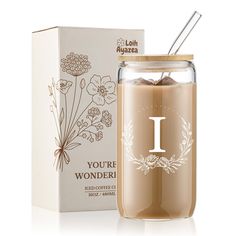 a glass jar filled with liquid next to a cardboard box and flower design on the lid