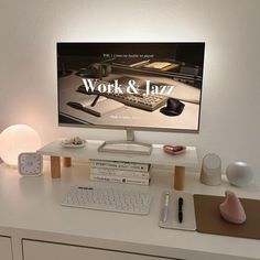 a desk with a computer, keyboard and mouse on it in front of a large screen