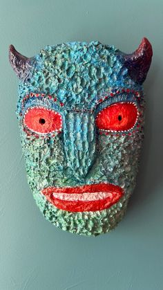 a colorful mask is hanging on the wall