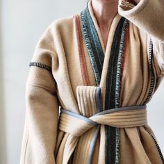 "This one of a kind wool robe, wrap coat is made from fabric remnants sourced from a U.S. heritage woolen mill. The body features a muted pink napped wool accented with graphite blanket stitch, marled moss panel down the center back, marled racing green shawl collar, and dove grey binding on the quilted belt. The belt is detachable if the wearer would prefer to style as a duster coat, body is unlined with no stretch, side seam pockets in marled forest green wool.  Body is approximately 32\" wide/across from shoulder seam down to hem.  Sleeves are approximately 16\" long from shoulder seam to cuff. Suggested to fit a size women's M to L. *Wearer in photo is 5'2\" and typically wears a size small in outerwear." Moss Panel, Wool Robe, Wool Duster, Wool Blanket Coat, Quilted Robe, Green Shawl, Blanket Coat, Muted Pink, Body Features