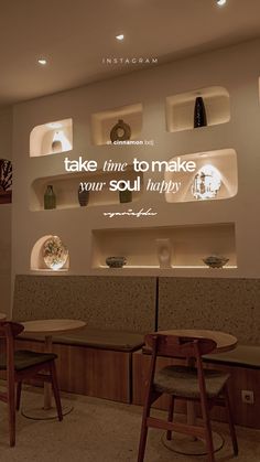 two wooden chairs sitting next to each other in front of a wall with shelves on it