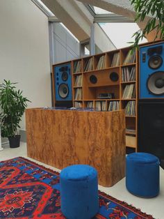 there are many speakers in the room and one is on top of a blue stool