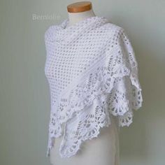 a white crocheted sweater on a mannequin with a dummy behind it