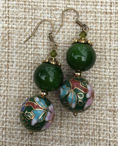 Two classic and royal designs for a timeless look. Black vintage Chinese handmade cloisonne beads with beautiful pink and green floral pattern, paired with black lava bead and red Swarovski pearl and 14 carat gold spacer bead . Green vintage Chinese handmade cloisonné beads with pink and blue floral pattern , paired with opaque green glass beads and Swarovski crystal . The earrings are 5.5 cm long. Enjoy! Cloisonne Jewelry, Cloisonne Earrings, Blue Green Gold, Unusual Earrings, Mother Of Pearl Necklace, Sea Glass Necklace, Lava Bead, Enamel Earrings, Swarovski Earrings