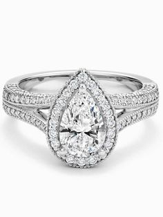 a pear shaped diamond engagement ring with split shans on the sides and an intricate band