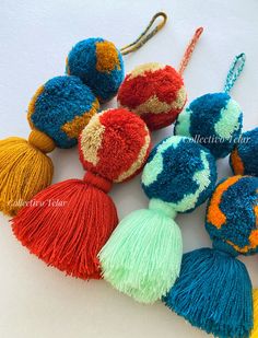 multicolored tasselled pom - poms are arranged on a white surface