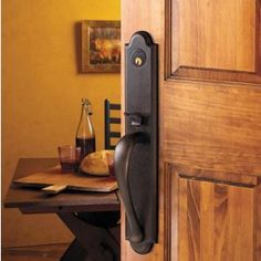 an image of a door handle that is on the side of a wooden door in front of a table