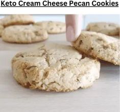 a person is picking up some cookies from the cookie sheet and placing them on top of each other