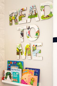 the wall is decorated with children's books and magnets that spell out read to me