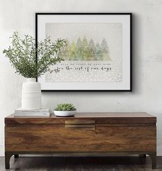 a wooden chest with a potted plant sitting on top of it next to a white wall