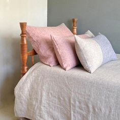 a bed with three pillows on top of it