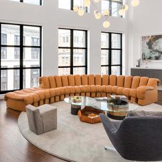 a living room filled with lots of furniture in front of large windows and floor to ceiling windows