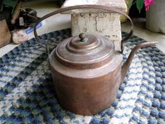 an old tea kettle sitting on top of a rug